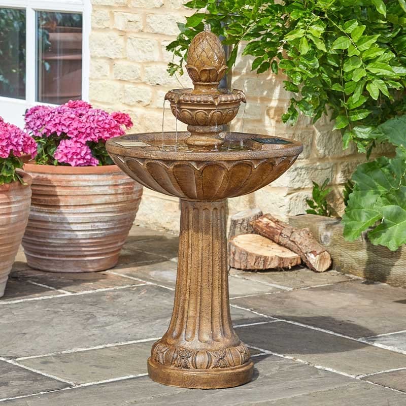 Smart Garden Queensbury Fountain — three-tier stone-effect solar water feature on a garden patio