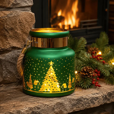 Emerald green glass Christmas lantern with a gold tree design glowing beside a fireplace.